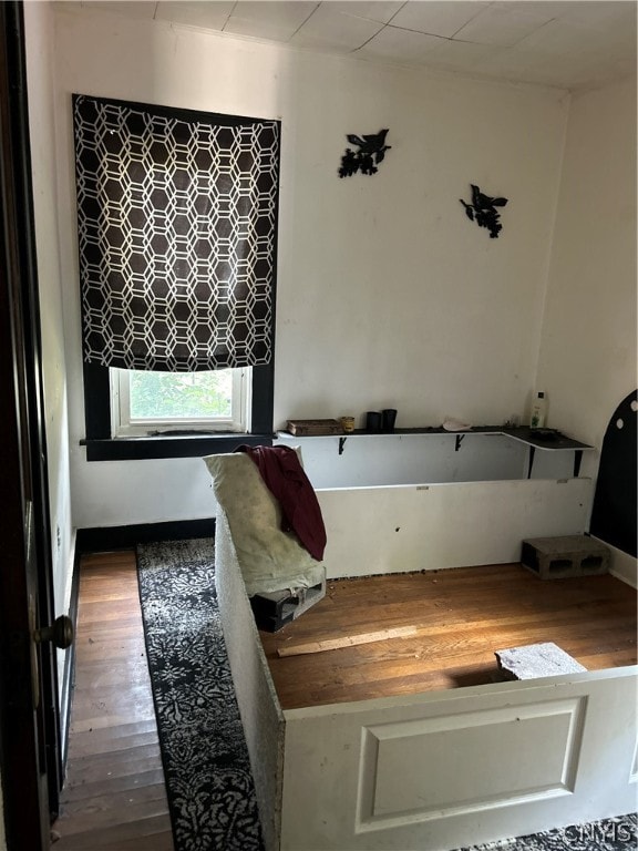 bathroom with hardwood / wood-style flooring and a bathtub