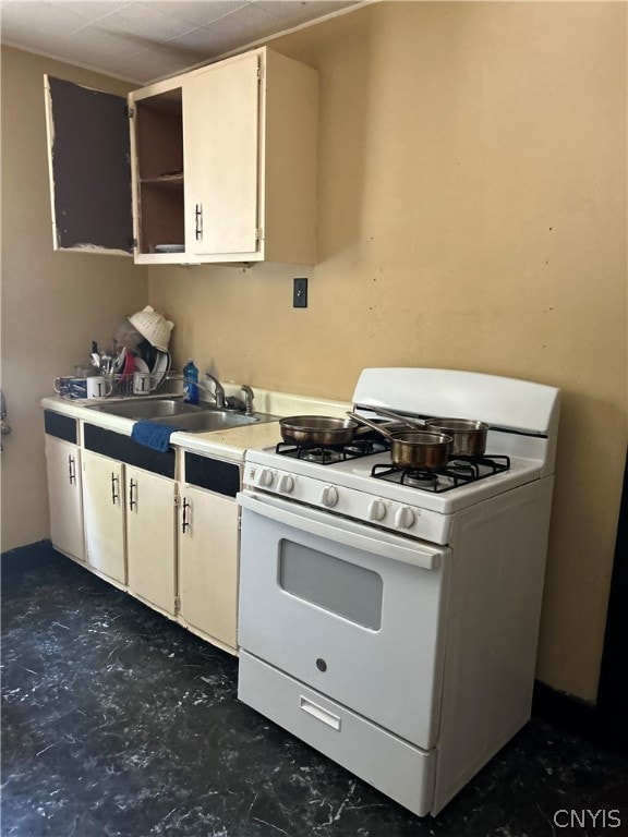 kitchen featuring white cabinets, gas range gas stove, and sink