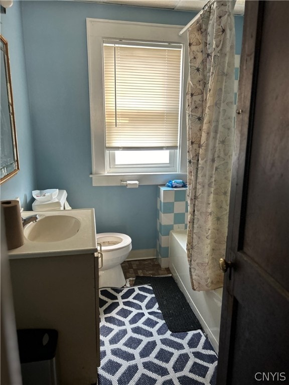 full bathroom featuring vanity, shower / bath combo with shower curtain, and toilet