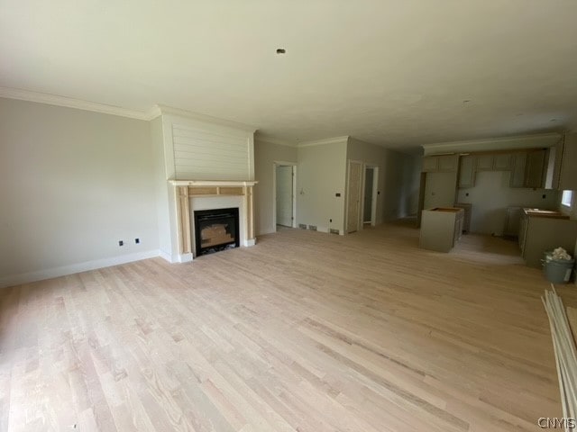 unfurnished living room featuring crown molding and light wood-type flooring