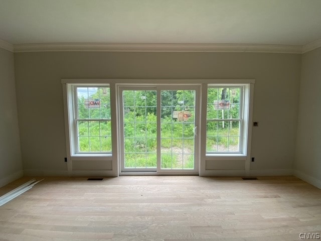 unfurnished room featuring ornamental molding and light hardwood / wood-style floors