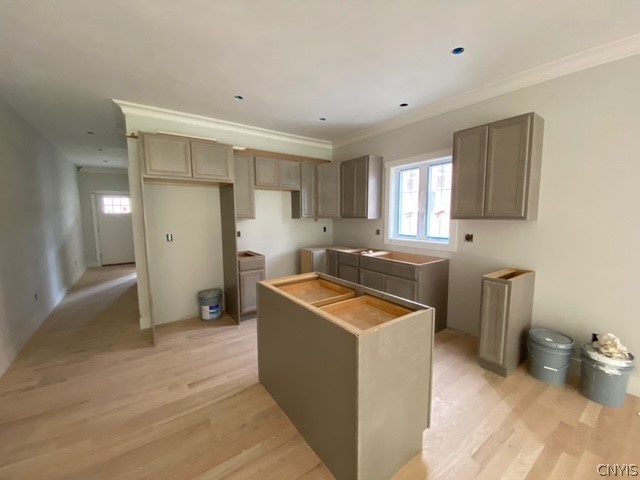 kitchen featuring light hardwood / wood-style floors, a center island, and crown molding