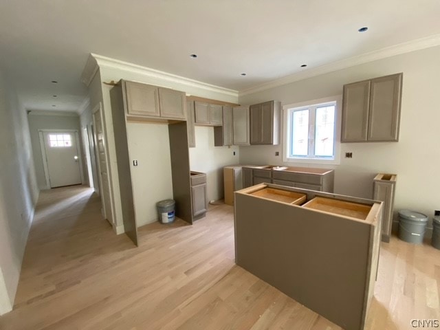 kitchen featuring a kitchen island, crown molding, and light hardwood / wood-style floors