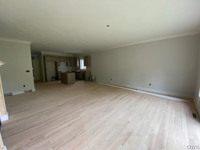 unfurnished living room featuring crown molding and light hardwood / wood-style flooring