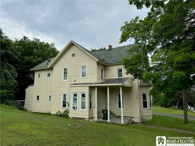 back of property with cooling unit and a yard