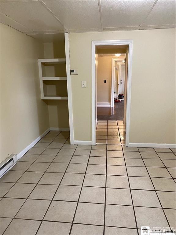 51 Fairmount Ave, Jamestown, NY 14701 - unfurnished room with light tile patterned flooring, a drop ceiling, and baseboards