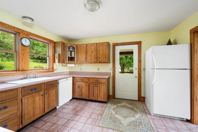 kitchen featuring white appliances, plenty of natural light, sink, and light tile patterned floors