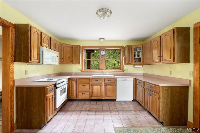 kitchen featuring white appliances, sink, and light tile patterned floors