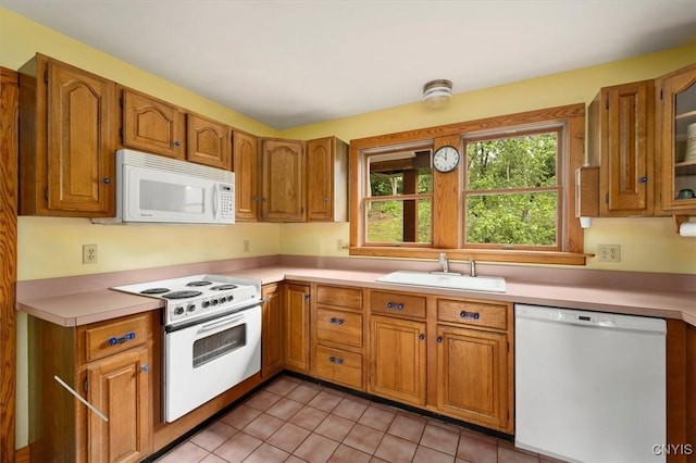 kitchen featuring sink, white appliances, and light tile patterned flooring