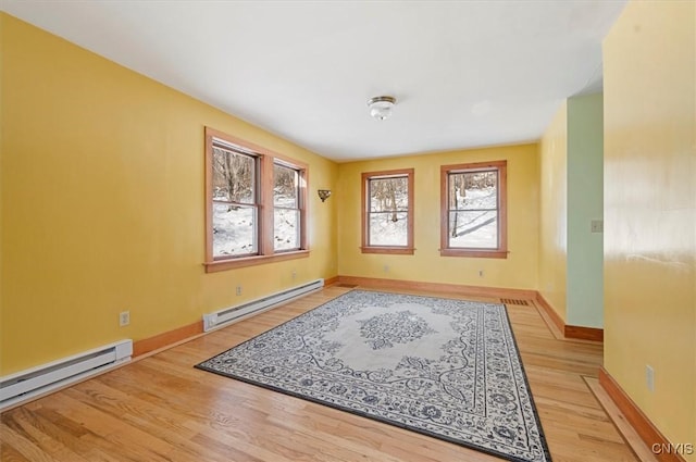 empty room featuring light wood-type flooring and baseboard heating