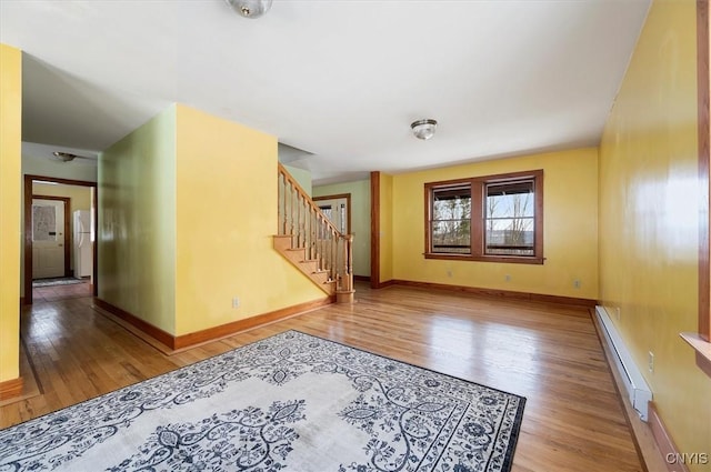 spare room with a baseboard heating unit and light wood-type flooring