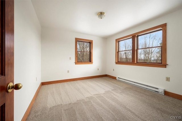 carpeted spare room with a baseboard heating unit