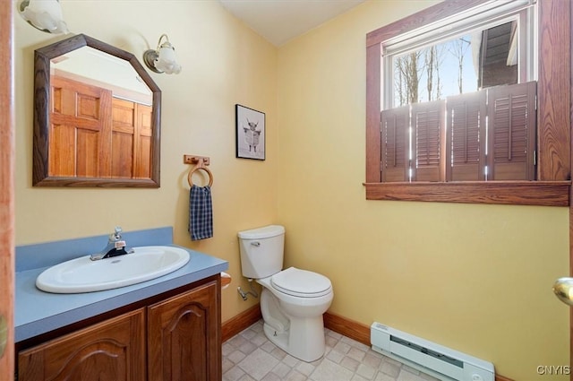 bathroom with vanity, baseboard heating, and toilet