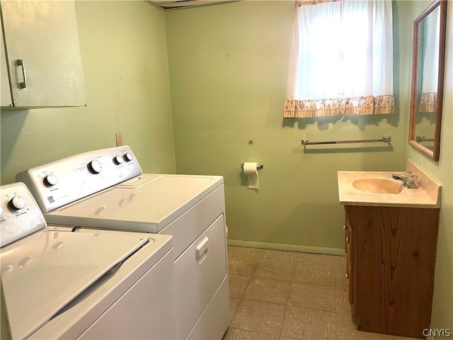 laundry area with sink, washing machine and dryer, and light tile patterned floors