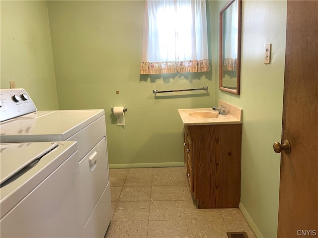 washroom featuring light tile patterned flooring, sink, and washing machine and dryer