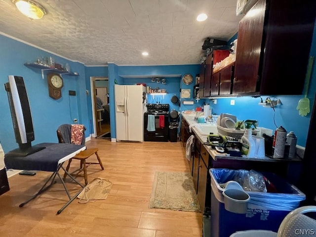 kitchen featuring dark brown cabinetry, light countertops, light wood-type flooring, black range oven, and white fridge with ice dispenser