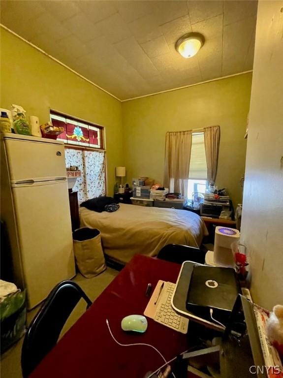 bedroom with freestanding refrigerator