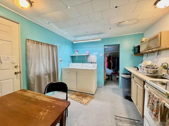 kitchen with a sink, light countertops, independent washer and dryer, light floors, and white electric range oven