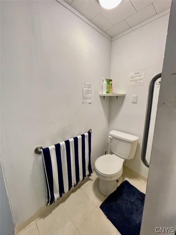 bathroom with a paneled ceiling, tile patterned flooring, toilet, and baseboards