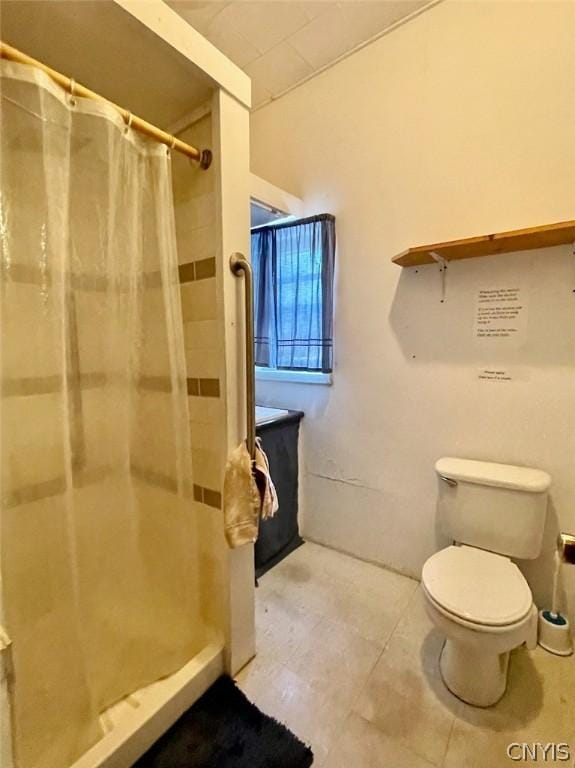 full bath featuring a stall shower, toilet, and tile patterned floors