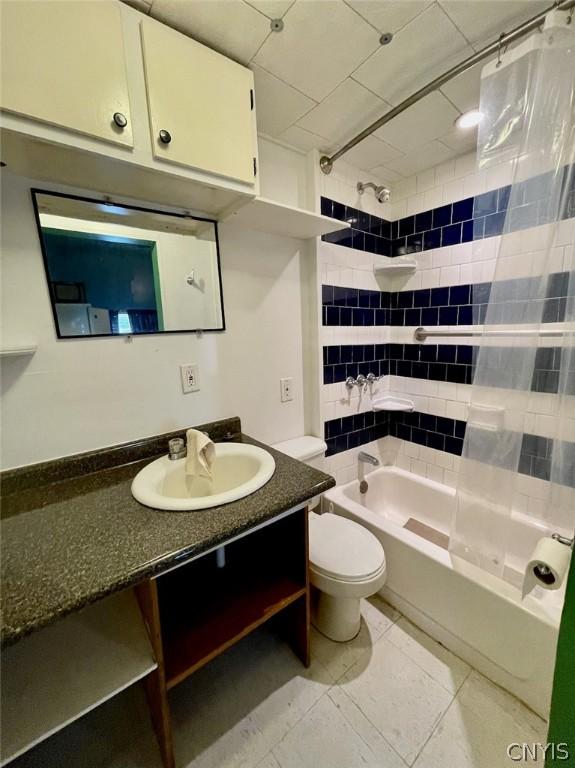 full bath featuring shower / tub combo with curtain, vanity, and toilet