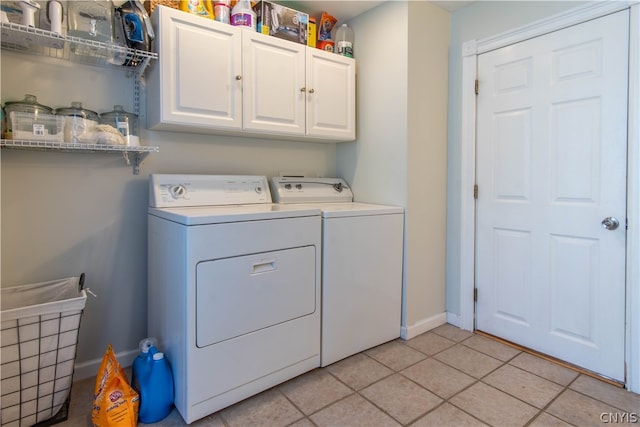 laundry room featuring cabinets, washing machine and dryer, and light tile patterned floors