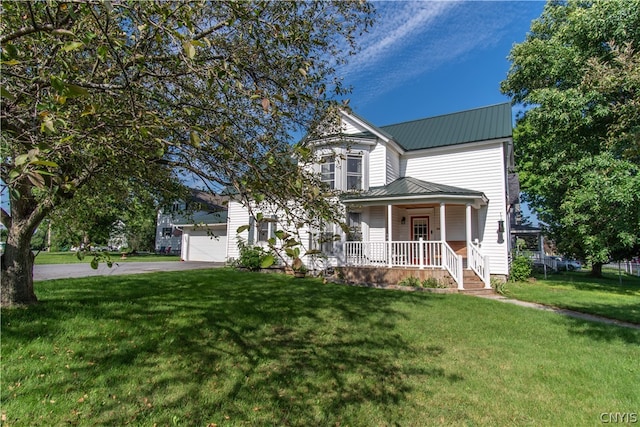 view of front of house featuring a porch, a garage, and a front yard