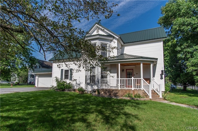 view of front facade with a garage, a porch, and a front yard