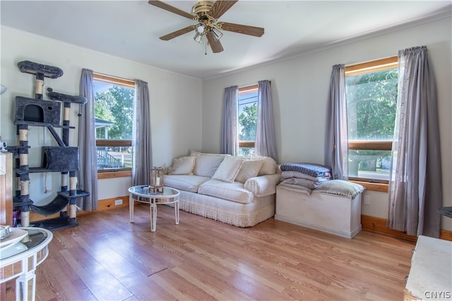 living room with crown molding, light wood-type flooring, and ceiling fan