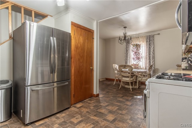 kitchen featuring a chandelier, dark tile patterned floors, crown molding, stainless steel refrigerator, and gas range gas stove