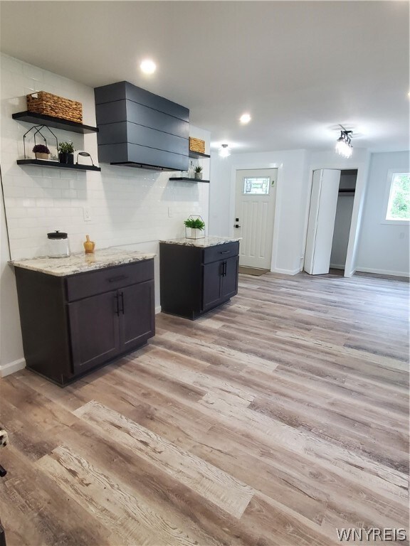 kitchen featuring light stone countertops and light wood-type flooring