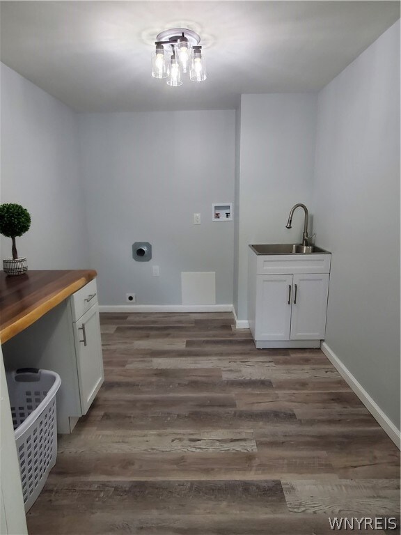 washroom with sink, cabinets, hookup for a washing machine, and hardwood / wood-style floors