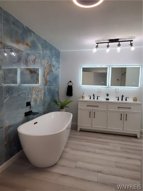 bathroom featuring tile walls, dual vanity, track lighting, and wood-type flooring