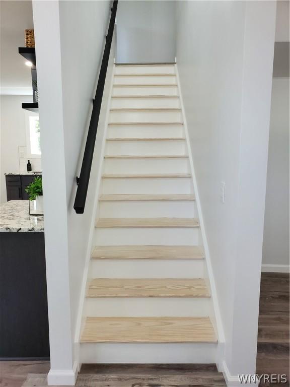 stairs featuring hardwood / wood-style floors