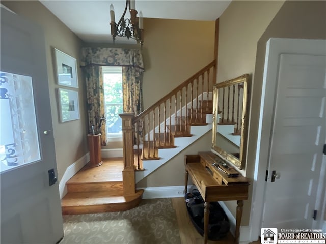 stairs with a chandelier and hardwood / wood-style floors