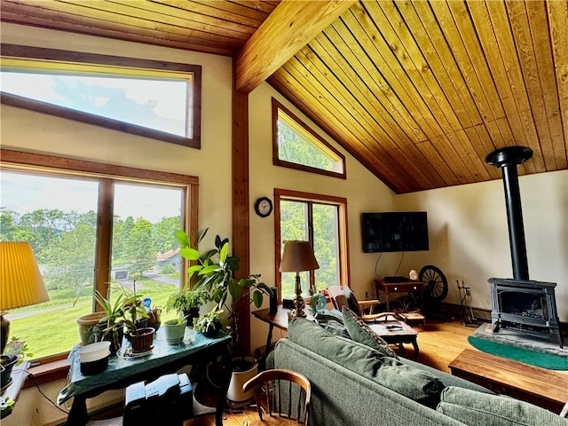 living room with wood ceiling, lofted ceiling with beams, plenty of natural light, and a wood stove