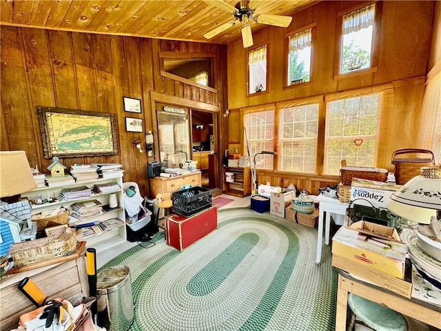 interior space with wood ceiling, wooden walls, high vaulted ceiling, and ceiling fan