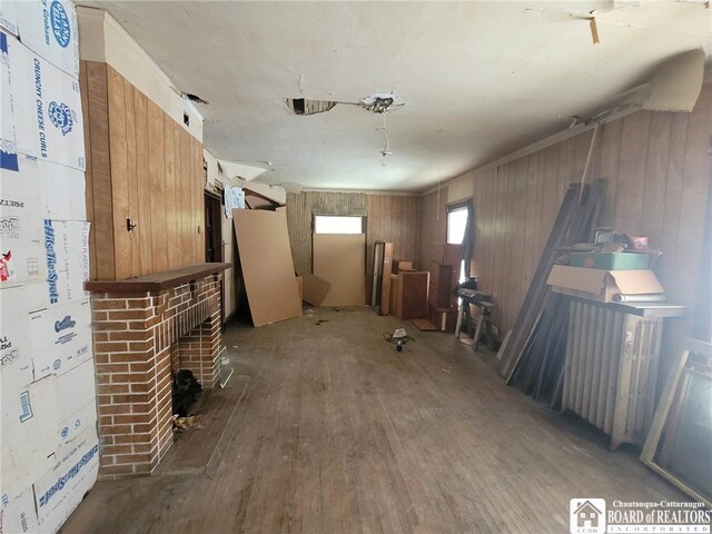 misc room featuring wood walls, a fireplace, and hardwood / wood-style floors