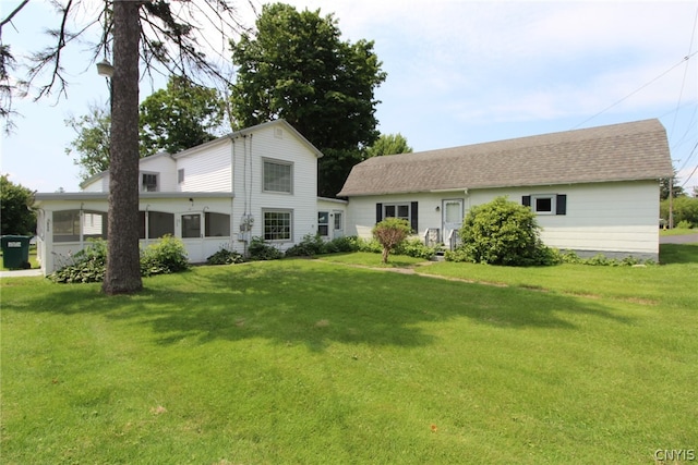 rear view of house featuring a lawn