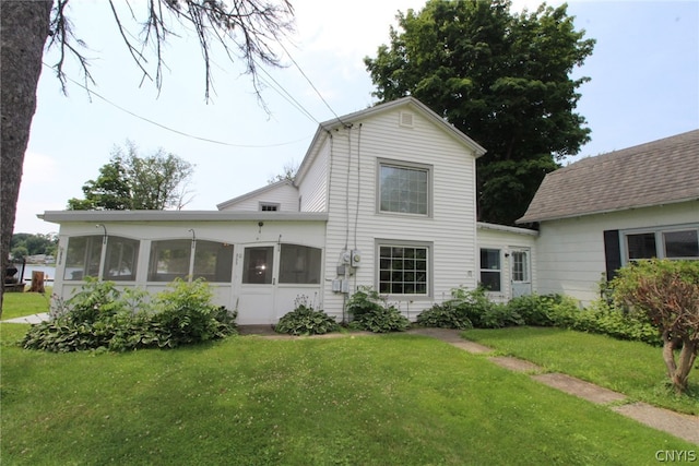 rear view of property with a sunroom and a yard