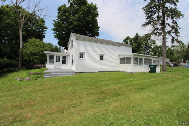 back of property with a yard and a sunroom