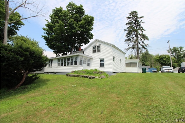 back of property featuring a yard and a sunroom