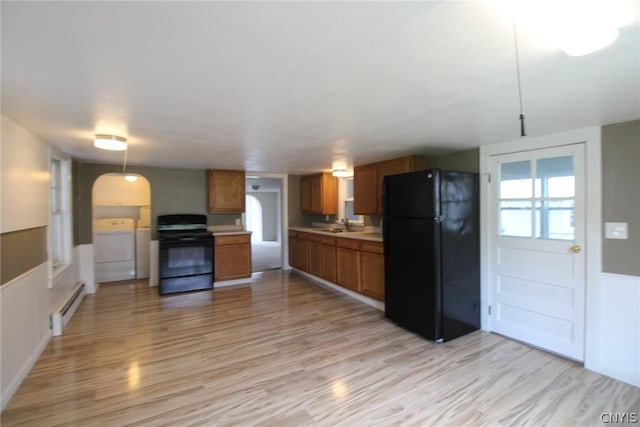 850 County Route 37, Hastings, NY 13036 - kitchen featuring black appliances, washer and dryer, baseboard heating, light wood-style floors, and light countertops