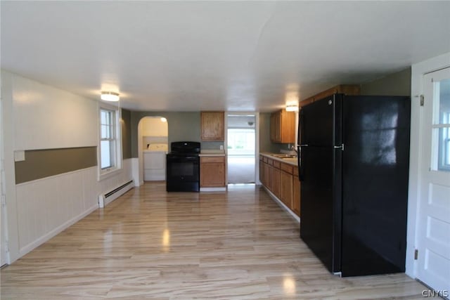 850 County Route 37, Hastings, NY 13036 - kitchen with black appliances, a baseboard radiator, light wood-type flooring, arched walkways, and brown cabinetry