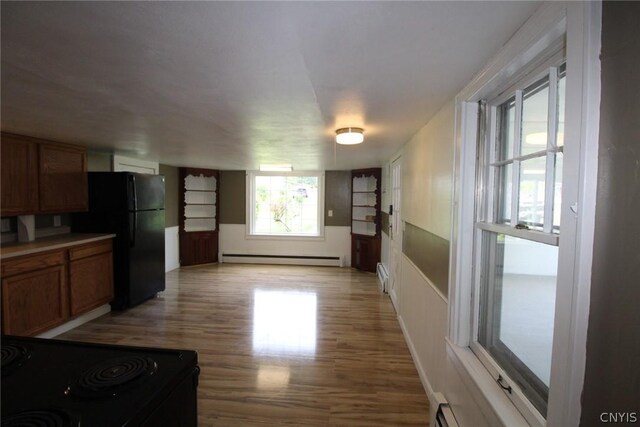 850 County Route 37, Hastings, NY 13036 - kitchen featuring a baseboard heating unit, black appliances, light wood-style flooring, and brown cabinetry