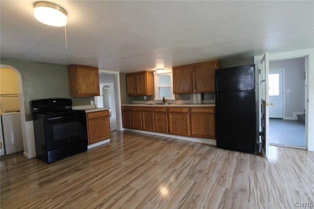 850 County Route 37, Hastings, NY 13036 - kitchen with black appliances, brown cabinetry, arched walkways, a sink, and light countertops