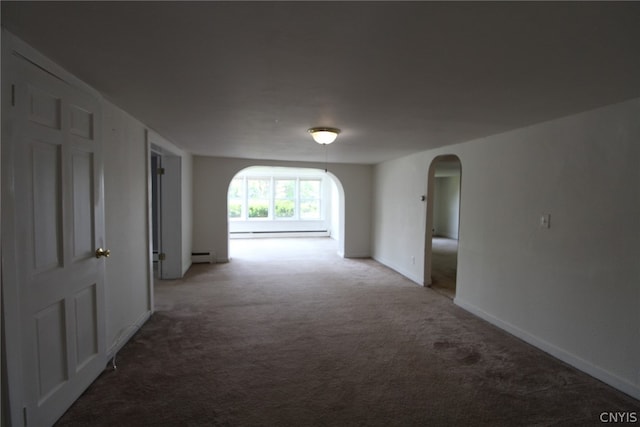 corridor with carpet floors and a baseboard heating unit