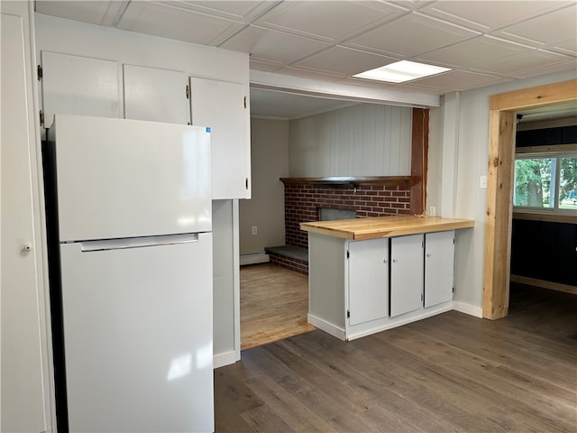 kitchen with white cabinetry, dark wood-type flooring, white refrigerator, and wood counters