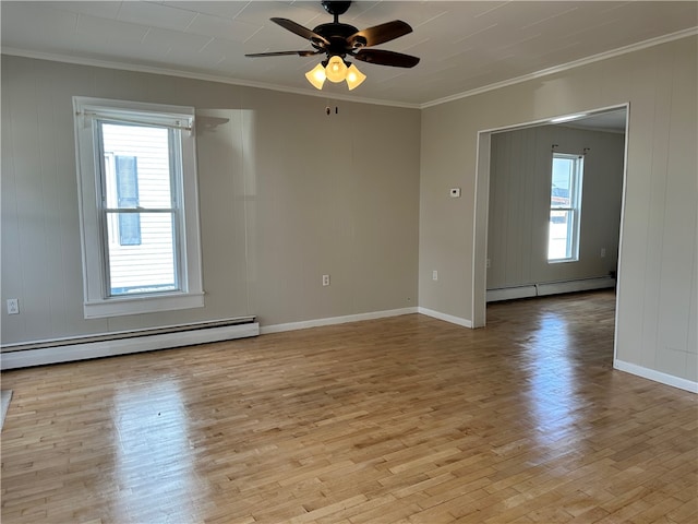 empty room featuring ceiling fan, crown molding, a baseboard heating unit, and light hardwood / wood-style floors