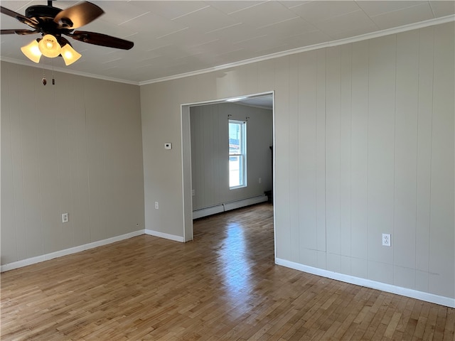 unfurnished room featuring hardwood / wood-style floors, ornamental molding, a baseboard radiator, and ceiling fan